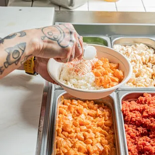 Fresh Sushi Grade Goodness!  Watch as our skilled staff scoops the finest ingredients into every bowl, ensuring a deliciously vibrant.