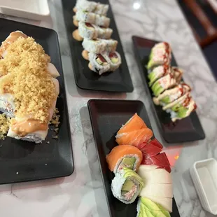 a variety of sushi on black plates