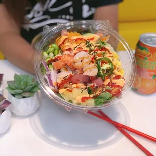 a person holding a bowl of poke sushi