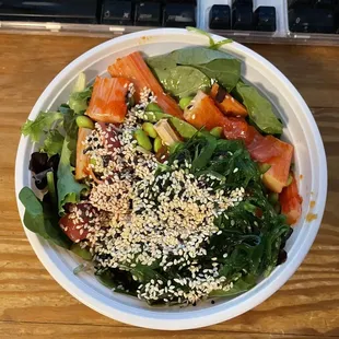 Build Your Own Bowl with mixed greens, krab, tuna, masago, edamame, sweet + hot sauce, seaweed salad, and sesame seeds