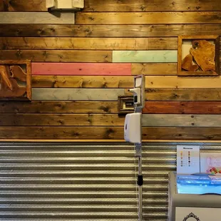 a toilet in a bathroom with a wooden wall behind it