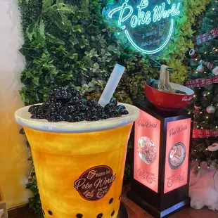 A Boba and Noodle Decoration Near a Sign of Poke World