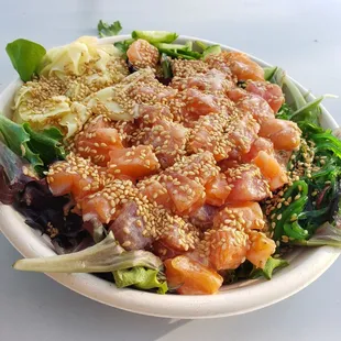 a bowl of salad with salmon and lettuce