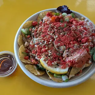 Medium poke bowl with yuzu ponzu sauce on the side (lid off). Base was nacho chips &amp; salad mix