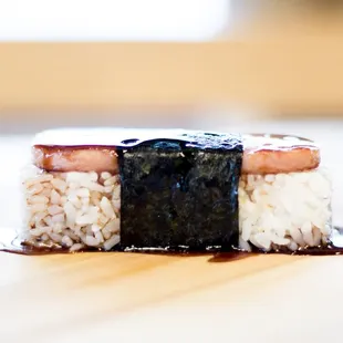 a piece of sushi on top of rice