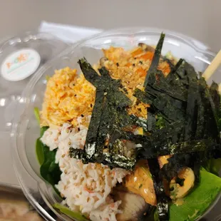 a bowl of sushi and rice with chopsticks