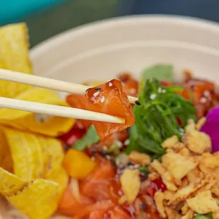 a bowl of food with chopsticks