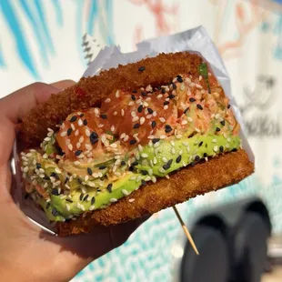a hand holding a sandwich