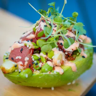 an avocado with tuna and vegetables