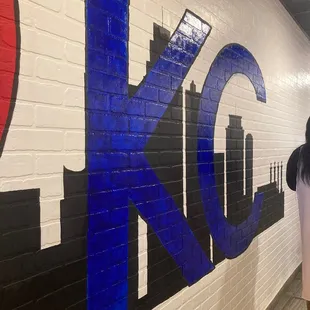 a woman standing in front of a painted wall