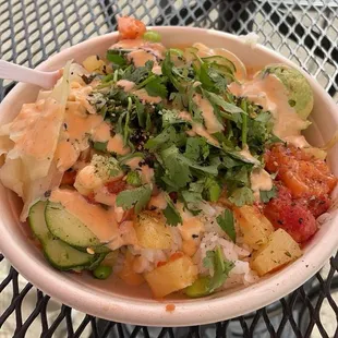 bowl with sushi rice, salmon, spicy tuna, cucumber, pineapple, edamame, spicy mayo and mild house sauce, avocado, ginger, cilantro
