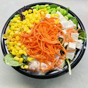 Brown rice, spring mix salad, salmon, tofu, edamame, corn, carrots, creamy sesame sauce.