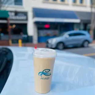 a cup of coffee on the hood of a car