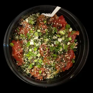 Fresh Tuna Poke Bowl with chopped green onions, sesame seeds, seaweed mix and house sauces.
