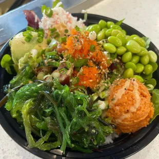 Specially marinated fresh spicy tuna poke bowl with vegetables. Topped with avocado, masago eggs, seaweed salad, edamame and crabmeat.
