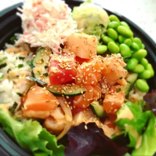 Healthy half salad and rice poke with fresh Salmon and Tuna. Avocado, cucumber, crabmeat, and nutritious edamame. Topped with sesame seeds.