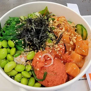 Small bowl with spicy tuna and salmon with half salad and brown rice.