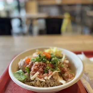 a bowl of rice with meat and vegetables