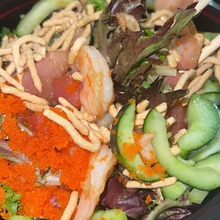 Mixed greens with ahi tuna yellow fin tuna and shrimp with masago cucumber seaweed salad and crunchy noodles with teriyaki sauce.