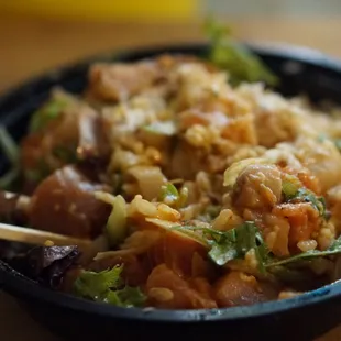 a bowl of food with chopsticks