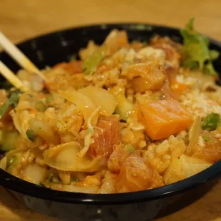 a bowl of food with chopsticks