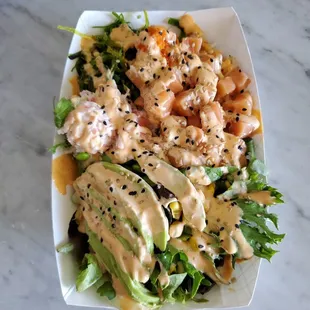 Salmon poki bowl with spring mix avocado ponzu soy Siracha mayo