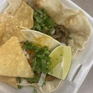 two tacos in a styrofoam container