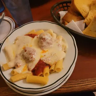Rigatoni and meatballs with cheese and garlic bread.