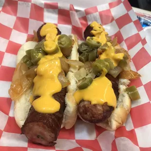 two hot dogs covered in cheese