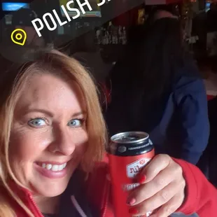 a woman holding a can of soda