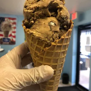 a hand holding a cone of ice cream