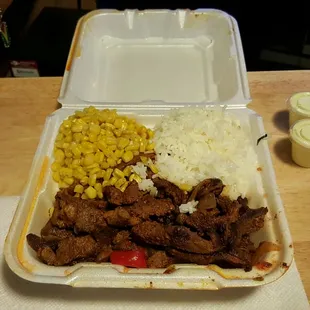 a takeout container with rice and corn