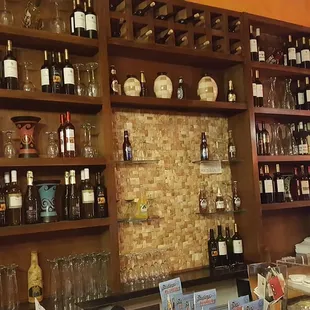 a wall of wine bottles and wine glasses