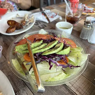 Iceberg lettuce, tomatoes, red onions, and avocado slices.