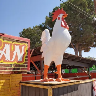 a large white chicken on top of a building