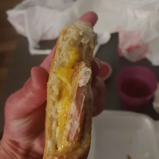 a hand holding a half eaten sandwich