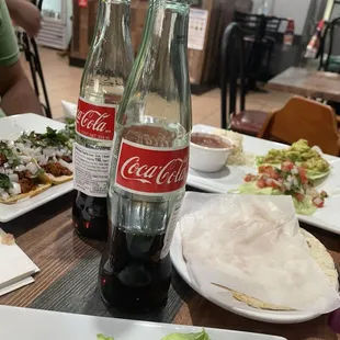 Coke served by the bottle. Next to freshly heated tortillas