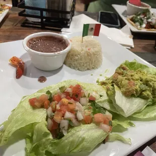 Fajita sides set-up, flavored white rice, guacamole, Pico de Gallo, and Refried Beans