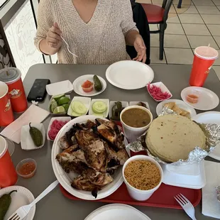 a woman sitting at a table full of food