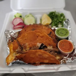 a takeout container with a chicken and vegetables