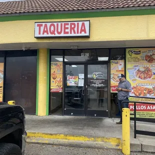 a man standing in front of a taqueria