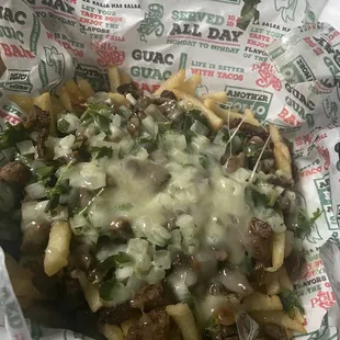 Carne asada fries with cheese and guacamole on side