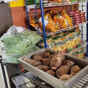 Groceries.  Taro leaves and Taro root in the foreground