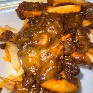 a plate of fries covered in cheese sauce