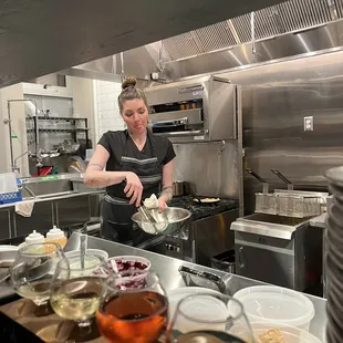 a woman preparing food in a commercial kitchen