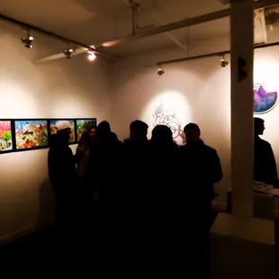 a group of people looking at artwork