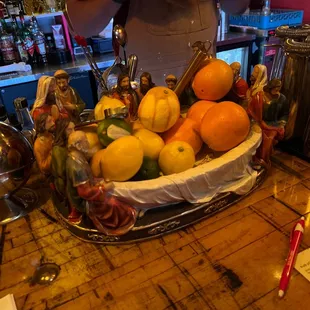 a person standing behind a bowl of fruit