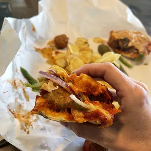 a hand holding a piece of pizza