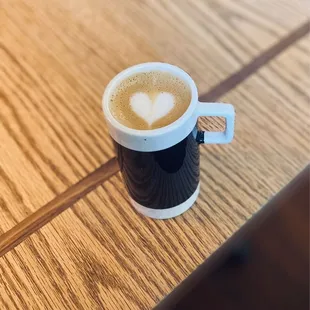 a cup of coffee on a wooden table