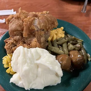 a plate of fried chicken, mashed potatoes, and green beans